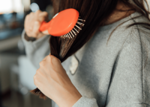 Image of a person brushing their hair with a detangler brush