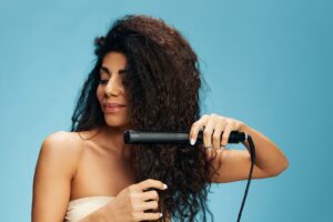 Image of a woman straightening her hair with a hair straightener