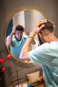 Image of a man looking at his hair in the mirror on Eldorado's website