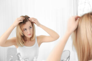A woman looking at her wig in the mirror