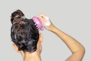 A person exfoliating their scalp