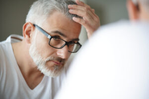 A man looking at his hair