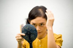 A woman looking at her expanding hairline