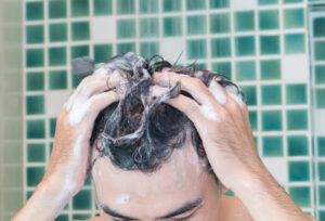 A man washing his hair in the shower